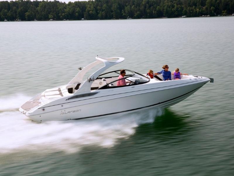 A Group of People on a 2017 Larson LXI 292 IO Bowrider Boat Speeding Through Water on a Lake.
